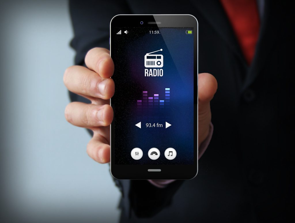 Modern,media,concept:,businessman,holding,a,modern,smartphone,with,radio